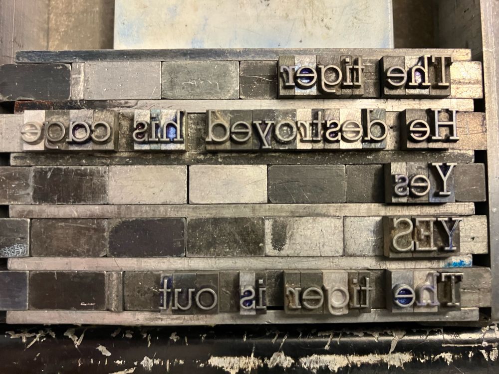 Photo of metal printing press type, arranged into a poem